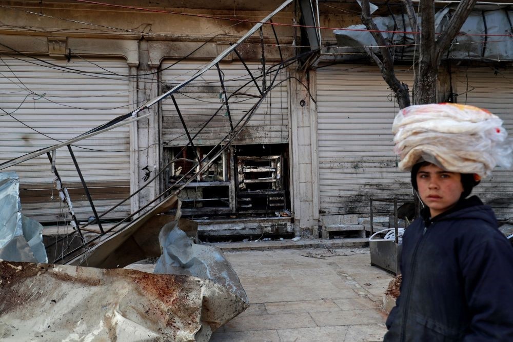 A Syrian boy walks past the site of a suicide attack in the flashpoint northern Syrian city of Manbij, which killed four U.S. serviceman, Jan.17.
