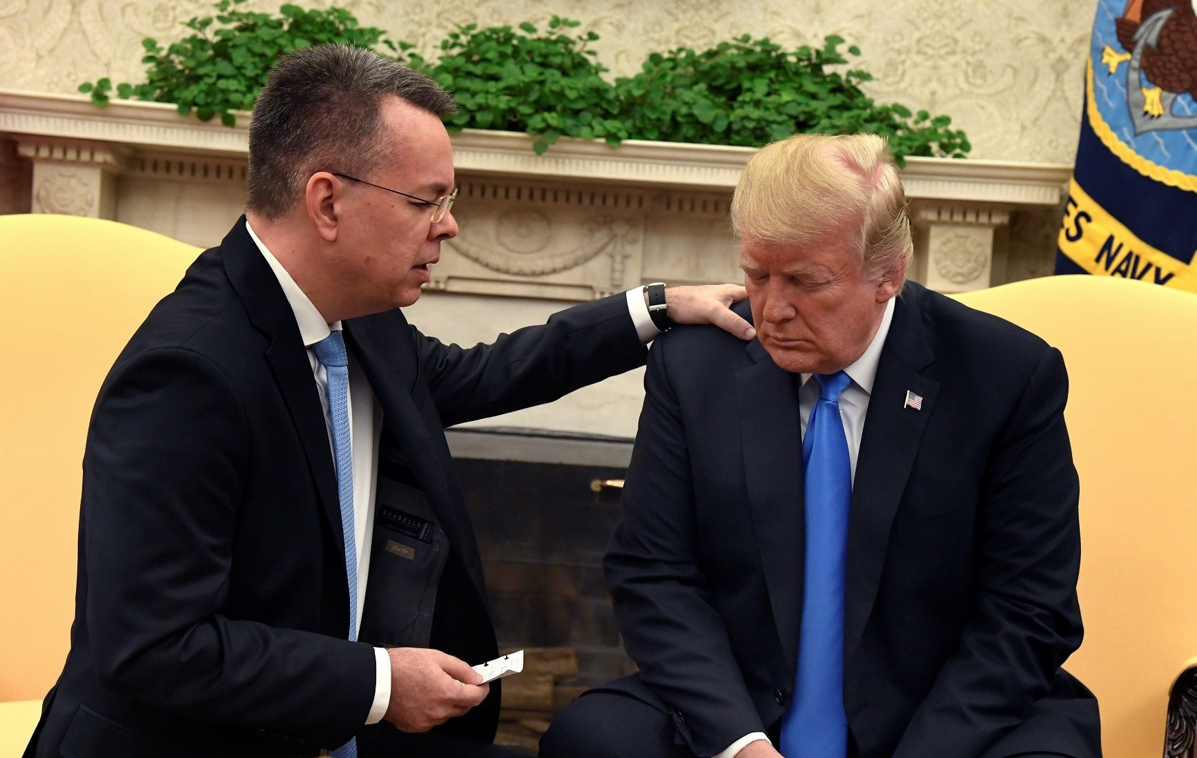 U.S. President Donald Trump closes his eyes in prayer along with pastor Andrew Brunson, after his release from two years of detention in Turkey, in the Oval Office of the White House, Washington, Oct. 13. 