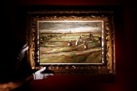 A staff presents a painting entitled 'Raccommodeuses de Filets dans les Dunes' (Women Mending Nets in the Dunes) by Dutch artist Vincent Van Gogh at the Artcurial headquarter in Paris (EPA Photo)