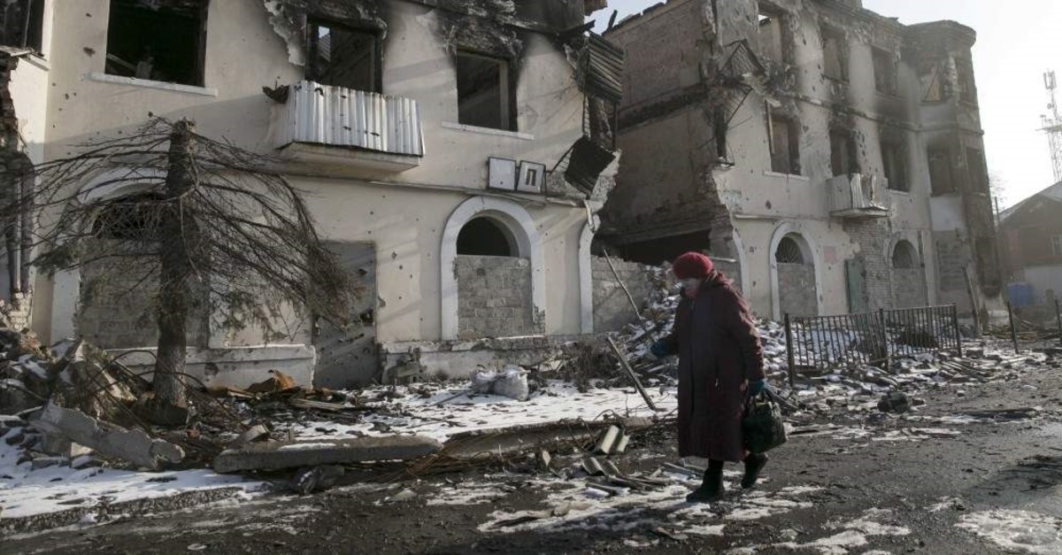 A woman walks past a damaged building in the town of Vuhlehirsk, Donetsk, Feb. 14, 2015. (REUTERS Photo)