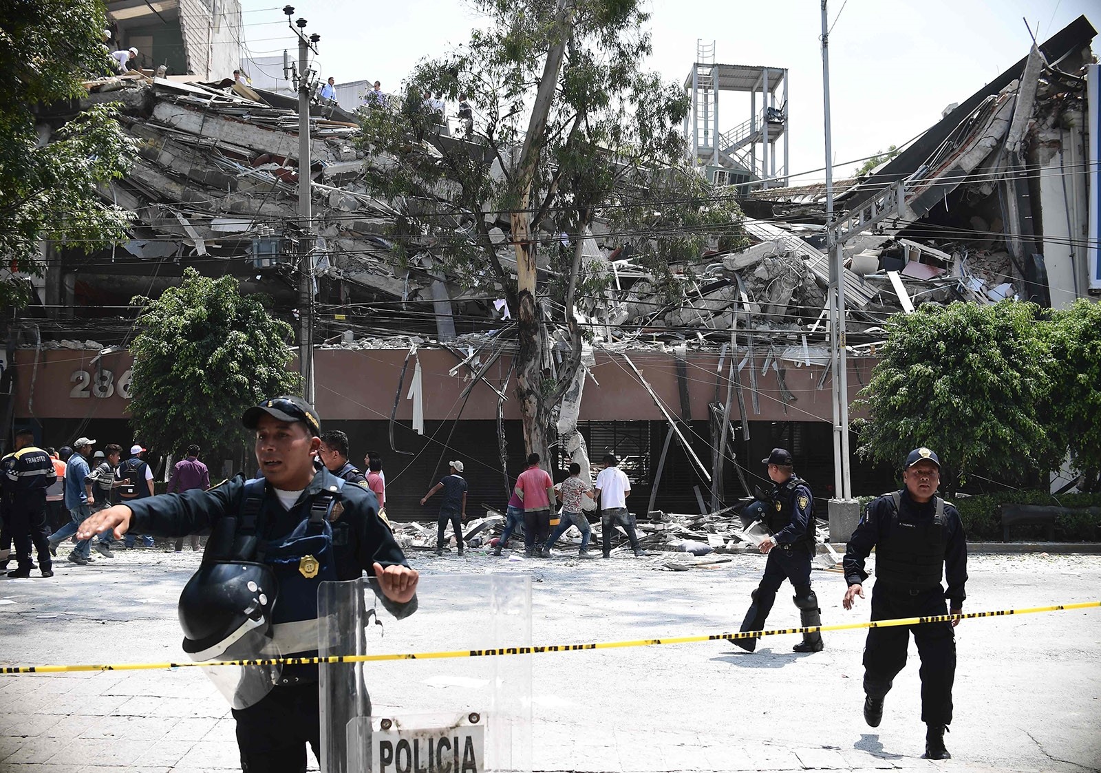 Police officers cordon the area off after a building collapsed during a quake in Mexico City on September 19, 2017. (AFP Photo)