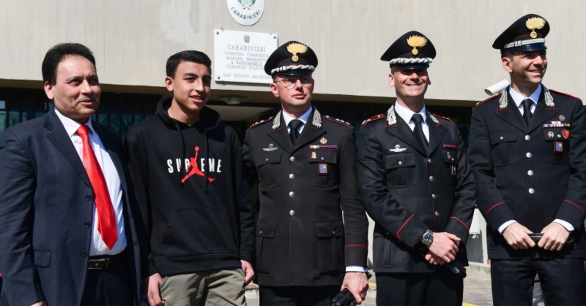 14-year-old schoolchild Ramy Shehata meets along with his father Khaled Shehata (L) with some of the Carabinieri policemen who came for help, on March 21, 2019 at the San Donato Milanese Police Station, southeast of Milan. (AFP Photo)
