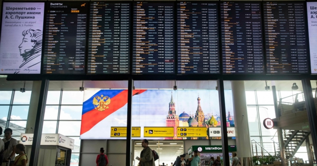 Passengers walk past a departure board at Sheremetyevo international airport in Moscow, Russia, Monday, July 8, 2019. (AP Photo)