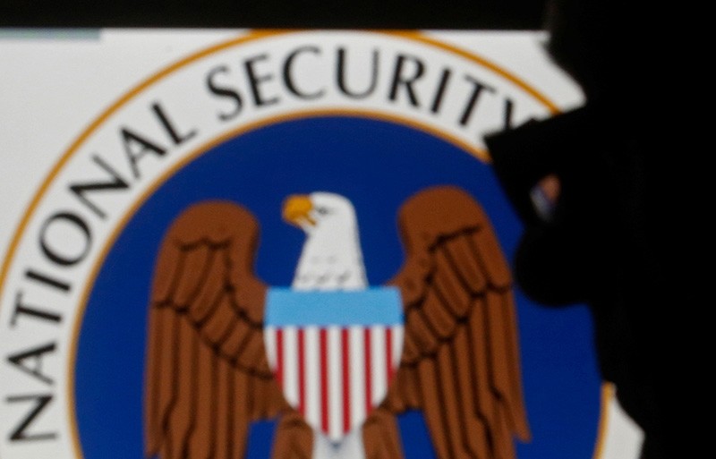 A man is silhouetted near logo of the U.S. National Security Agency (NSA) in this photo illustration taken in Sarajevo March 11, 2015.  (Reuters Photo)