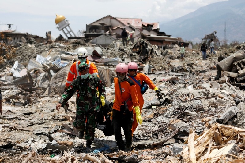 Rescue workers and a soldier remove a victim of last week's earthquake in the Balaroa neighbourhood in Palu, Central Sulawesi, Indonesia October 6, 2018. (REUTERS Photo)
