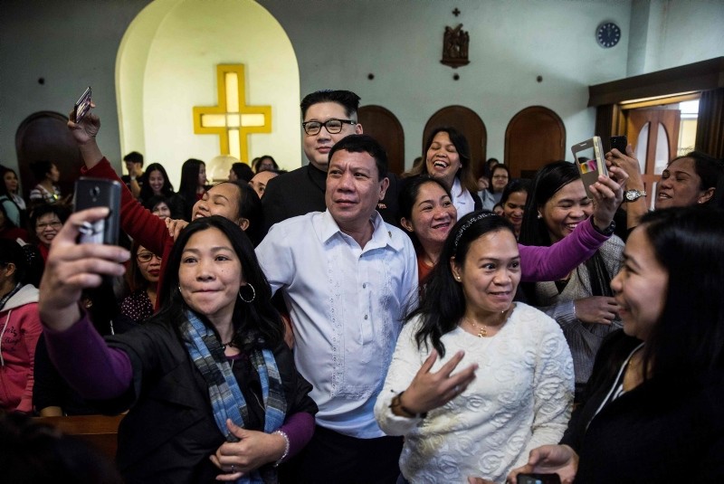 A Philippine President Rodrigo Duterte impersonator, who goes by the name Cresencio Extreme, and a North Korean leader Kim Jong Un impersonator, who goes by the name Howard X, attend a church service in Hong Kong, Feb. 3, 2019. (AFP Photo)