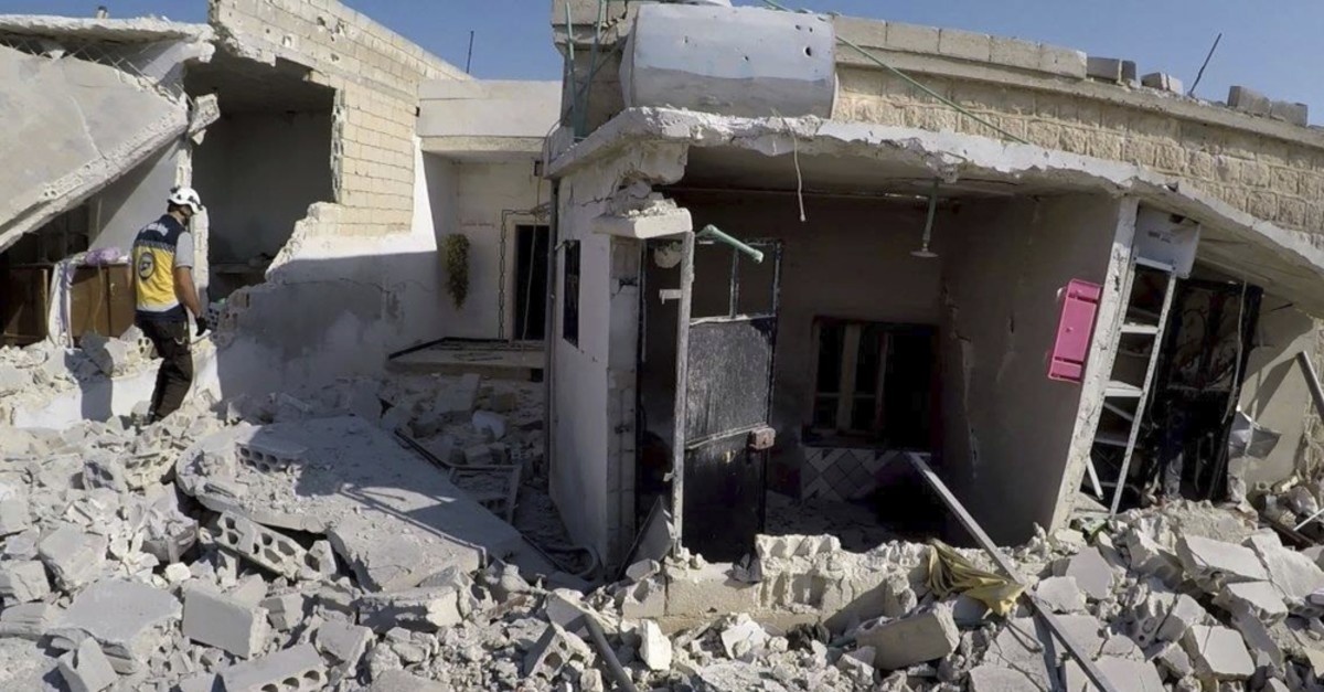 A White Helmets worker inspecting destroyed buildings after airstrikes hit the town of Jarjnas, in Idlib, Aug.28, 2019.