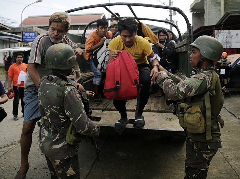 Filipino villagers who were trapped in the fighting between Daesh terrorists and government forces, are escorted by soldiers following their escape to freedom in Marawi City, June 03, 2017 (EPA Photo)
