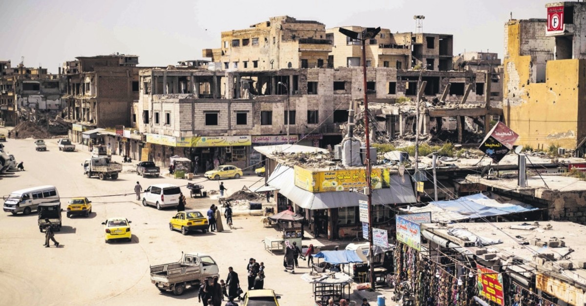 People walk along a market street in the northern Syrian city of Raqa, April 14, 2019.