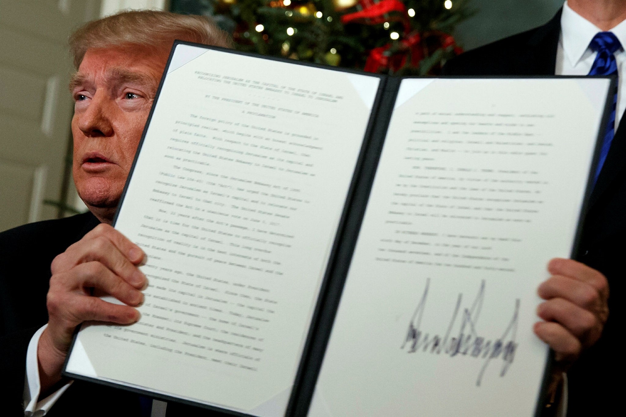 President Donald Trump holds up a proclamation to officially recognize Jerusalem as the capital of Israel, in the Diplomatic Reception Room of the White House, Wednesday, Dec. 6, 2017, in Washington. (AP Photo)