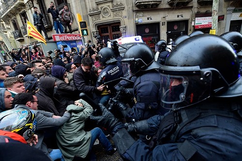 Protesters scuffle with riot police blocking the road leading to the central government offices at a demonstration in Barcelona on March 25, 2018 (AFP Photo).