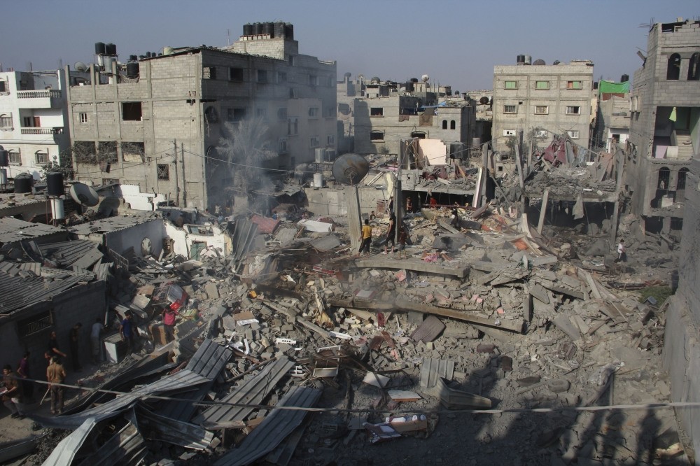 Palestinians stand on the rubble of houses destroyed in an Israeli strike in Rafah, southern Gaza Strip, Aug. 2, 2014.