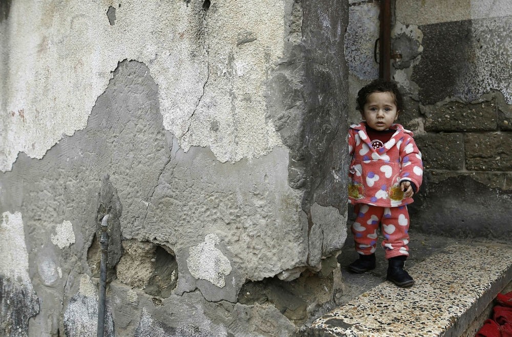A Palestinian toddler stands outside her family home at the al-Shati refugee camp, Gaza City, Jan. 17.