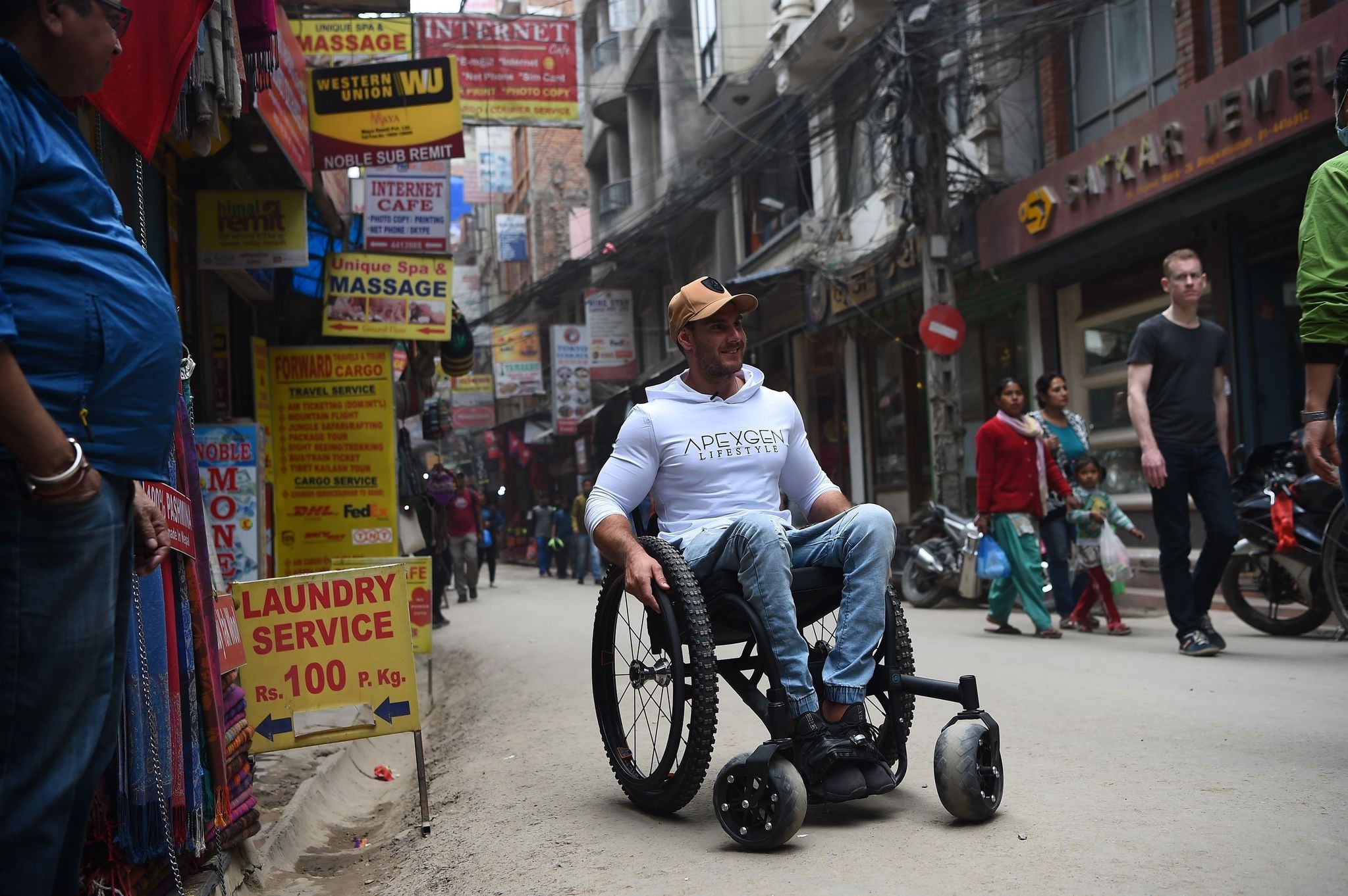 In this picture taken on March 15, 2018 wheelchair-bound Australian Scott Doolan makes his way along a street in Kathmandu. (AFP Photo)