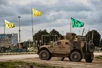 A patrol of US military vehicles is seen near the flying yellow flags of the terrorist YPG-dominated SDF and green flags of its constituent YPJ in the town of Tal Tamr in the northeastern Syrian Hasakah province along the border with Turkey on Feb. 8, 2020. (AFP Photo)