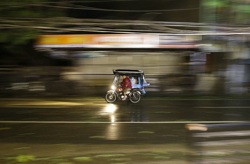 A man rides his tricycle as strong winds and rain from Typhoon Mangkhut batter Tuguegarao city, Cagayan province, northeastern Philippines on Saturday, Sept. 15, 2018. (AP Photo)