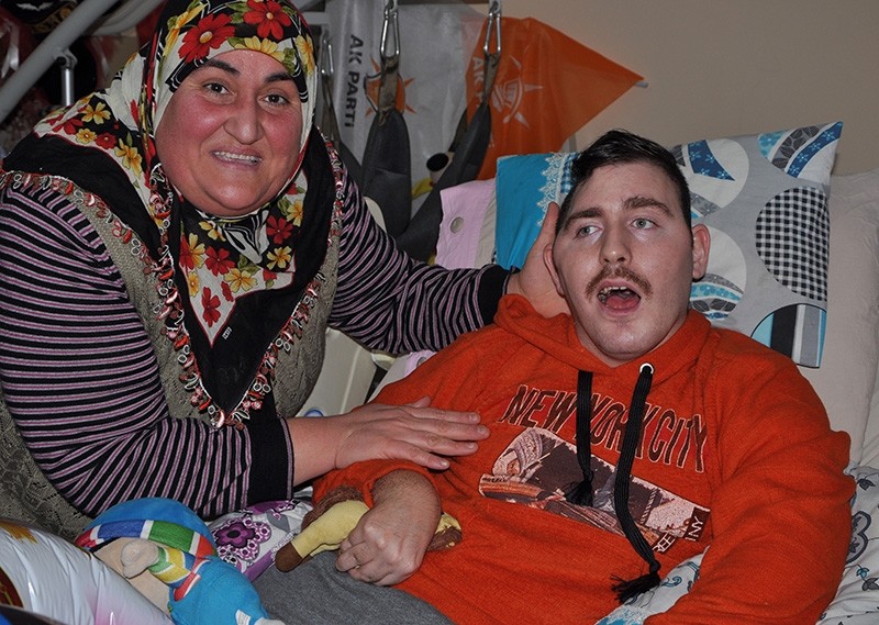Gu00fclsu00fcm Kabadayu0131 (left) smiles in a photo with paralyzed Russian boy she named Umut and had been taking care of since 2008 (IHA File Photo)