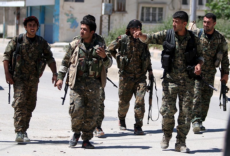 People's Protection Units (YPG) terrorists walk along a street in the southeast of Qamishli city, Syria, April 22, 2016. (Reuters Photo)