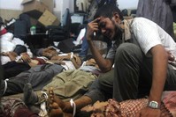 A man grieves as he looks at one of many bodies laid out in a make shift morgue after Egyptian security forces stormed two huge protest camps at the Rabaa al-Adawiya square. (AFP Photo)