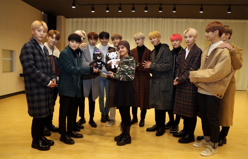 Havin Ayu015fe Baldaz (center) poses with members of K-Pop band Seventeen.