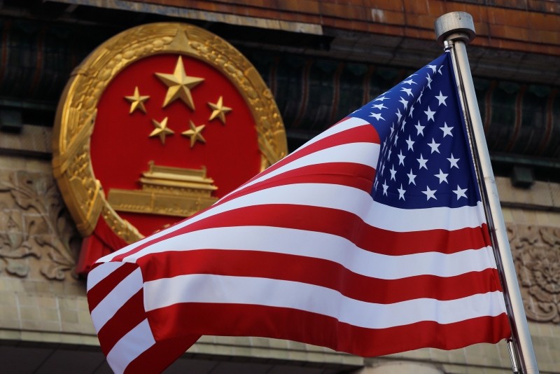 In this Nov. 9, 2017, file photo, an American flag is flown next to the Chinese national emblem during a welcome ceremony for visiting U.S. President Donald Trump. (AP Photo) 