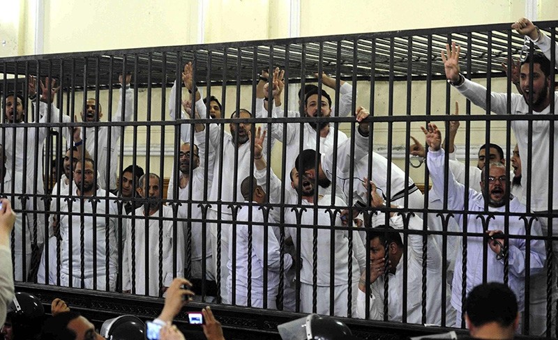 Supporters of the Muslim Brotherhood and ousted President Mohamed Morsi, standing trial on charges of violence, react after two fellow supporters were sentenced to death, in a court in Alexandria in this March 29, 2014, file photo. (Reuters Photo)