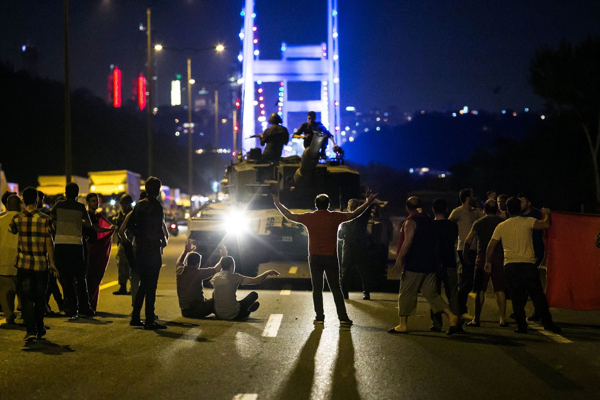 People take over a tank occupied by pro-coup troops near the Fatih Sultan Mehmet bridge on July 15, 2016.