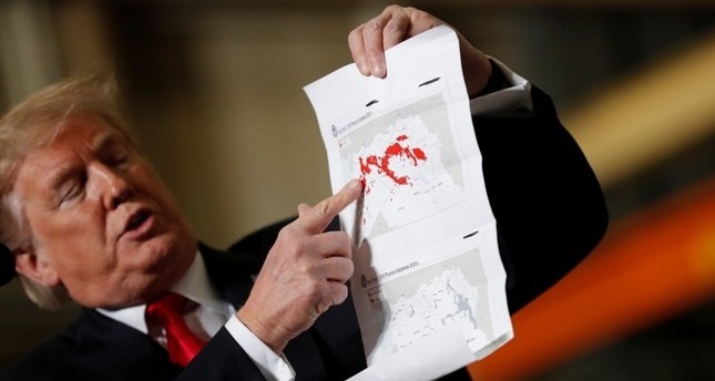 ترامب يظهر للصحفيين خريطة للأراضي التي تم استردادها من تنظيم داعش الإرهابي في سوريا  رويترز