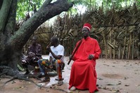 The kingdom is under the reign of King Sibilumbai Diedhiou,  wearing all red, carrying straws of a bamboo broom as a symbol of power and sitting on a stool as a symbol of modesty.