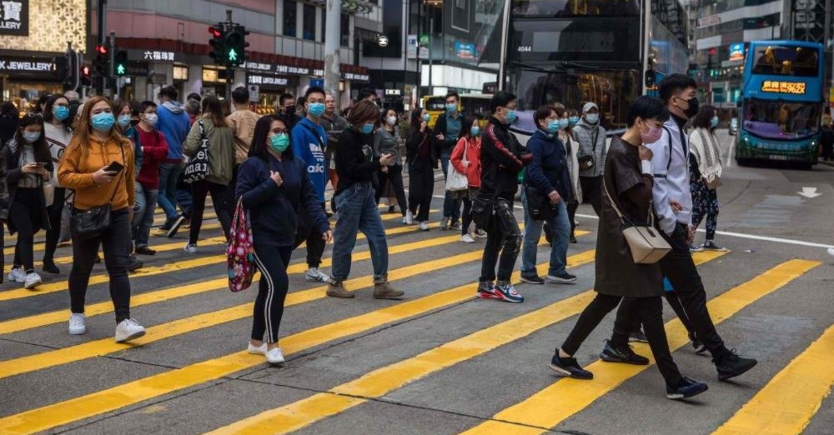 People wearing masks cross a street in a shopping district in Hong Kong on Jan. 26, 2020, as a preventative measure following a coronavirus outbreak which began in the Chinese city of Wuhan. (Photo by DALE DE LA REY / AFP)