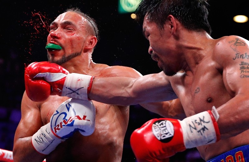 Manny Pacquiao, right, and Keith Thurman exchange punches in the second round during a welterweight title fight Saturday, July 20, 2019, in Las Vegas. (AP Photo)