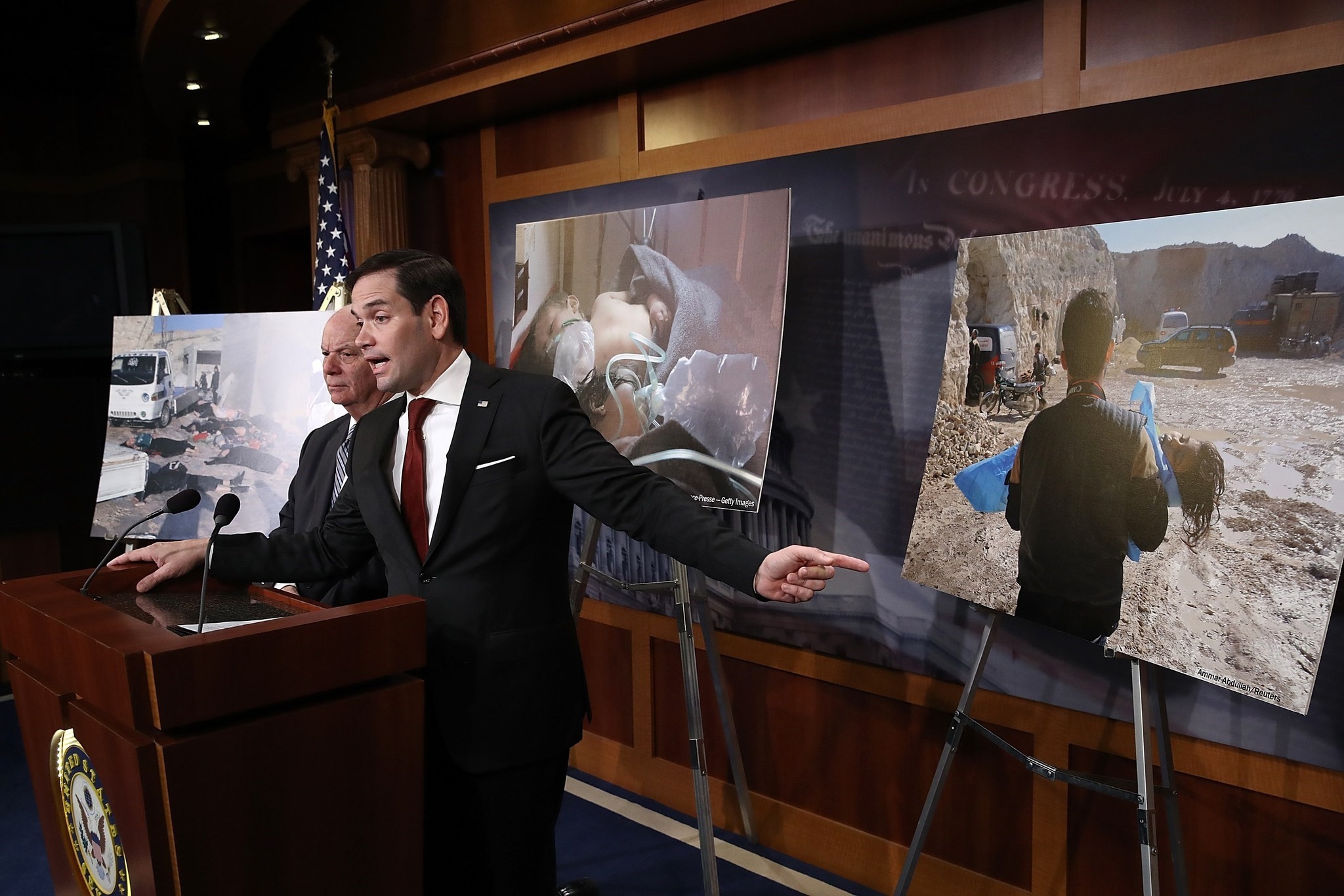  Surrounded by photographs of victims of yesterday's chemical weapon attack, Sen. Marco Rubio (R) speaks during a press conference at the U.S. Capitol. (AFP Photo)