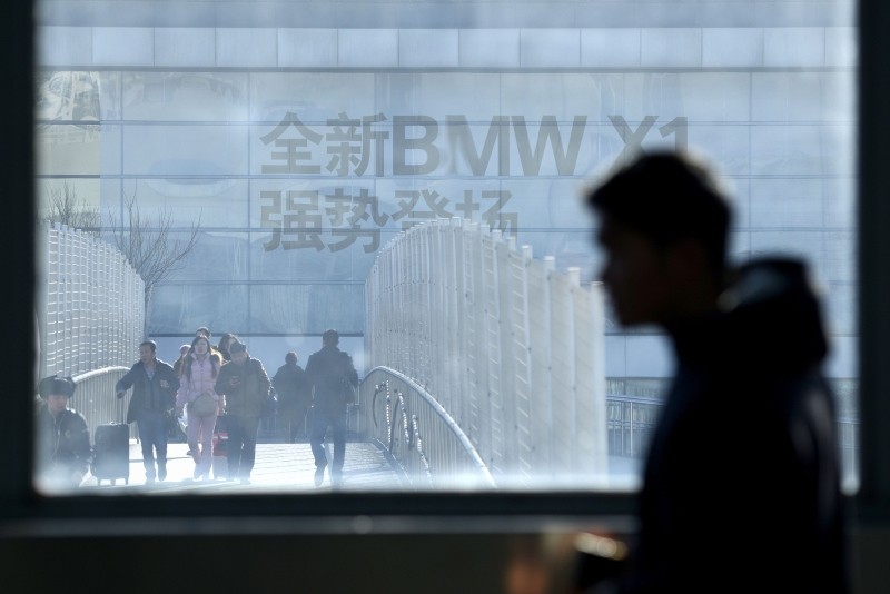 This Dec. 27, 2016 file photo shows an advertisement for German automaker BMW on the building of a BMW store, as seen through a window of a subway station in Beijing, China. (AFP Photo)