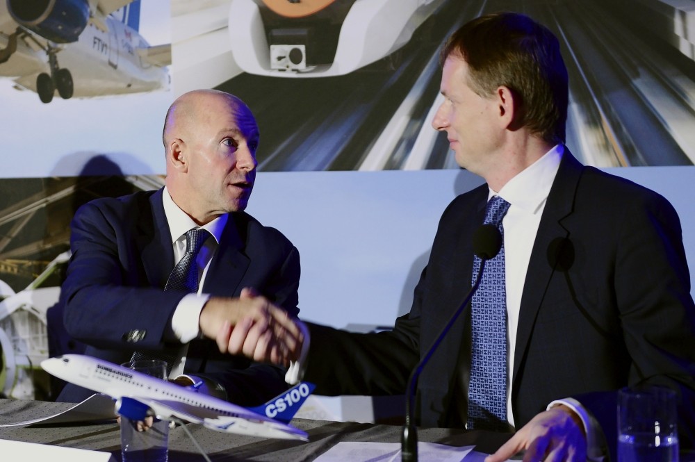 Bombardier CEO Alain Bellemare (L), and president Canada and COO of North America for Airbus Helicopters Romain Trapp shake hands during a press conference in Montreal on Monday.