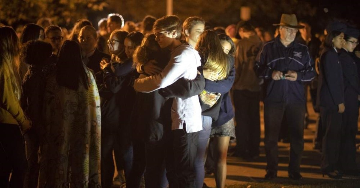 People affected by the Saugus High School shooting comfort each other during a vigil at Central Park in Santa Clarita, California, Thursday, Nov. 14, 2019. (Hans Gutknecht/The Orange County Register via AP)