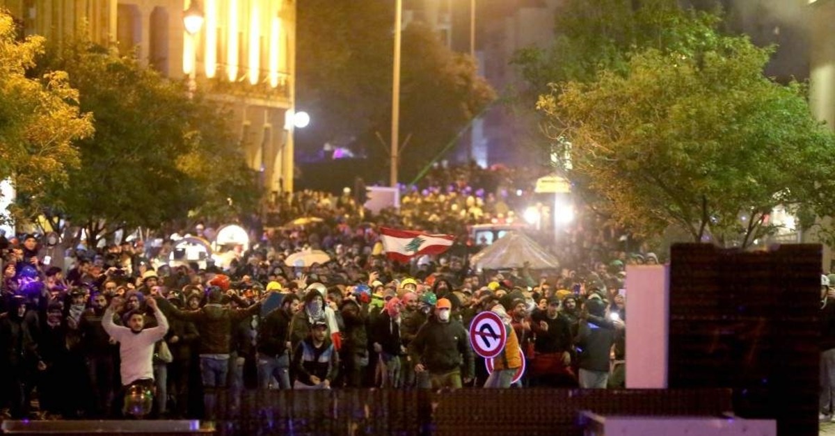 Lebanese protesters gather behind a barricade near a road leading to Parliament, Beirut, Jan. 19, 2020. (AFP Photo)