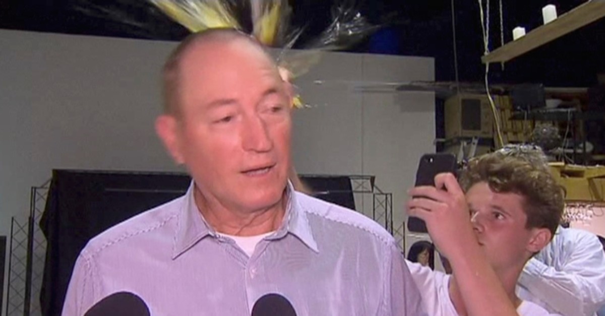In this image made from video, a teenager breaks an egg on the head of Senator Fraser Anning while he holds a press conference, Saturday, March 16, 2019 (AP Photo)