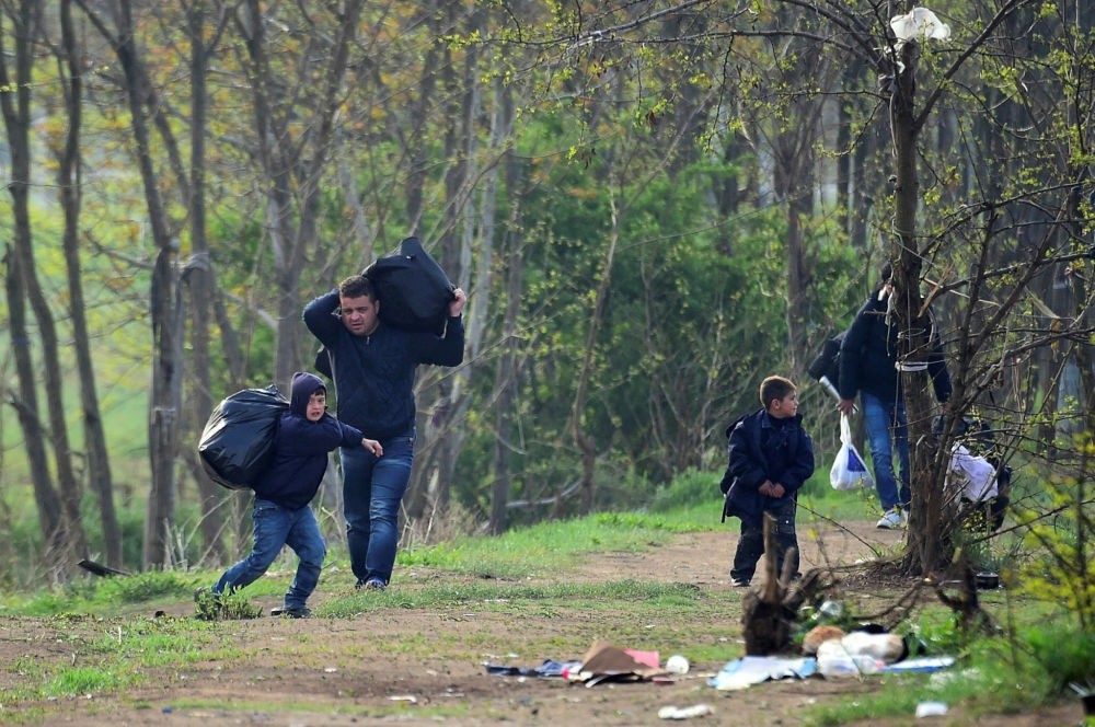 A Syrian family carry their belongings through the forest near the Hungarian border fence at the Tompa border station transit zone on April 6. (AFP Photo)