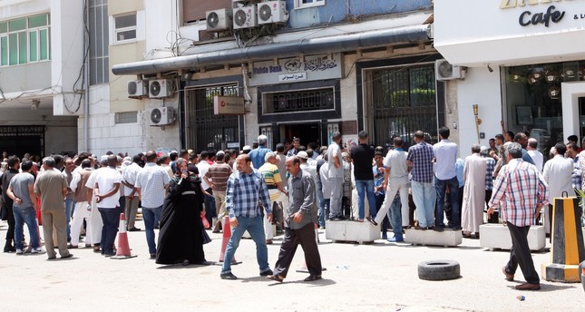 People form long lines in front of a bank in Tripoli, Libya.