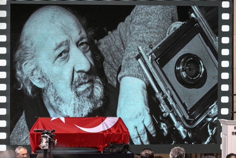 Slide shows and videos of Güler and his work are projected onto the screen at the memorial ceremony.