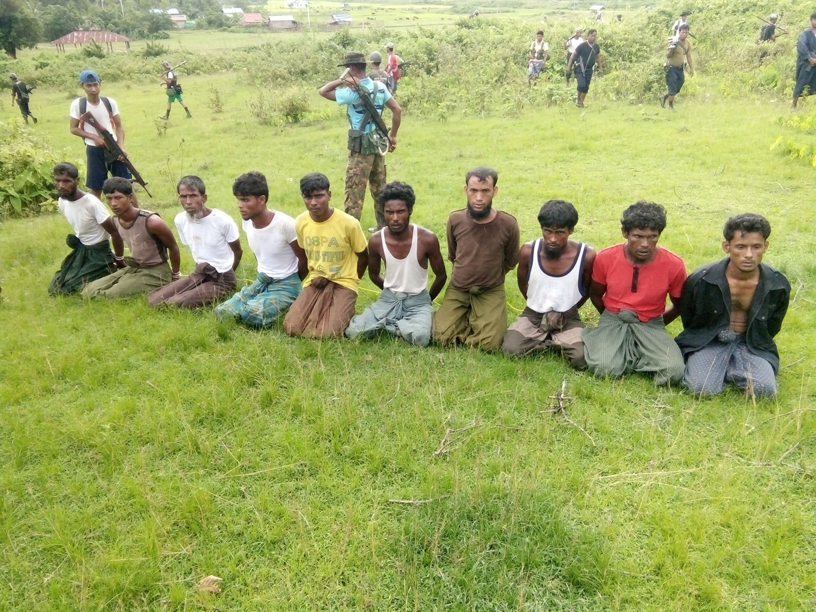 Ten Rohingya Muslim men with their hands bound kneel as members of the Myanmar security forces stand guard in Inn Din village September 2, 2017.