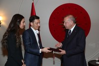Mesut u00d6zil, center, and his fiancu00e9e Amine Gu00fclu015fe, left, give a wedding invitation to President Recep Tayyip Erdou011fan at the Atatu00fcrk Airport in Istanbul, March 15, 2019. (AA Photo)