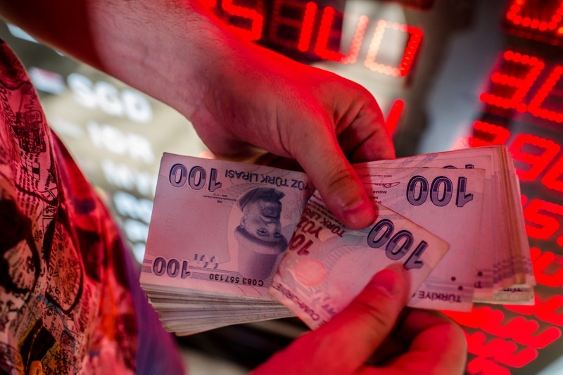 This Aug. 8, 2018 photo shows a money changer counting Turkish lira banknotes at a currency exchange office in Istanbul. (AFP Photo)
