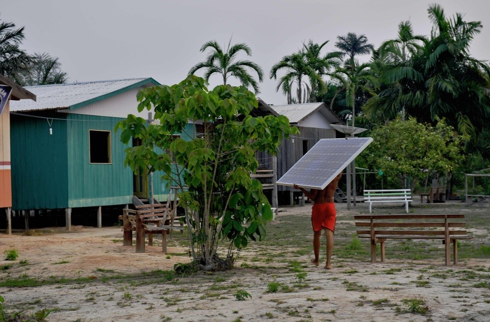 Solar panels donated by the World Wildlife Fund (WWF) and Brazilian government are carried to the village of Volta do Bucho in the Western Amazon region.