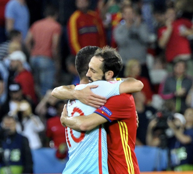 Ein spanischer Spieler umarmt Arda Turan auf dem Spielfeld (DHA Foto)