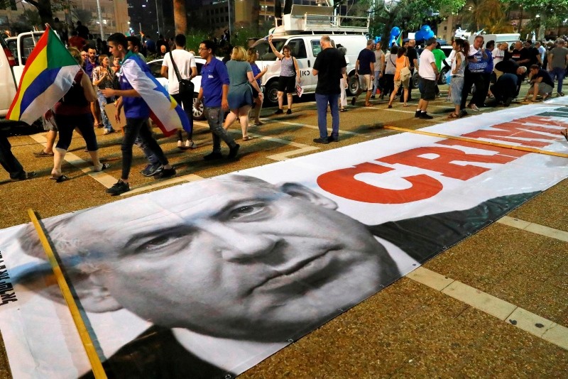 A banner with a political message and a picture of Israeli Prime Minister Benjamin Netanyahu is spread on the ground as protesters rally against the 'Jewish Nation-State Law' in Tel Aviv on August 4, 2018. (AFP Photo)