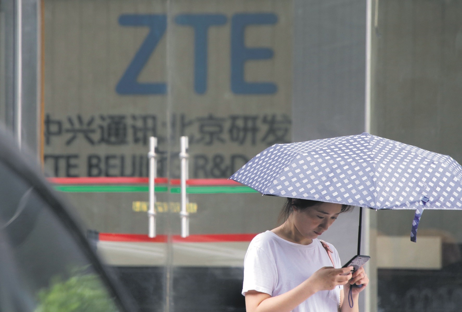 A woman stands outside ZTE Beijing research and development center in Beijing.