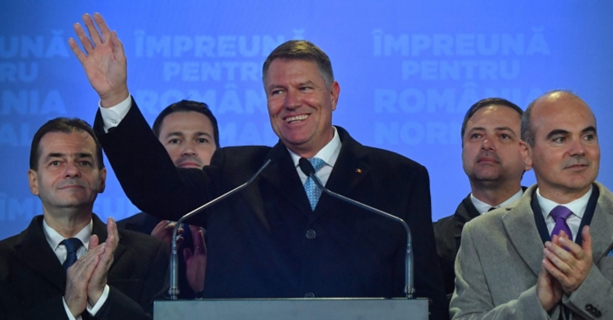Romania's President Klaus Iohannis waves as he addresses the media at the ruling National Liberal Party (PNL) headquarters, in Bucharest on November 24, 2019 after exit poll results of the presidential elections were announced. (AFP Photo)
