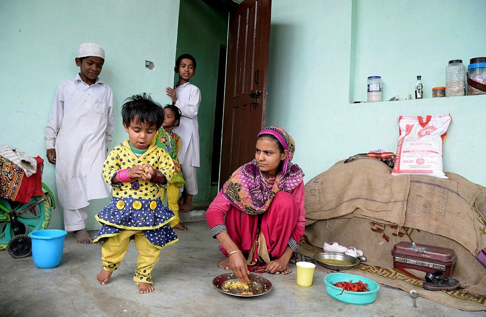 A Rohingya refugee feeds her daughter in a building on the outskirts of Srinagar on September 14, 2017. (AFP Photo)