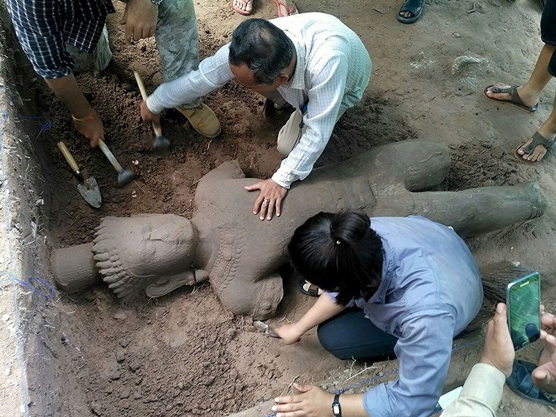 This handout photo taken on July 30, 2017 and released on August 1, 2017 by the Apsara Authority shows archaeologists excavating a statue from the ground at the complex in Siem Reap province. (AFP Photo)